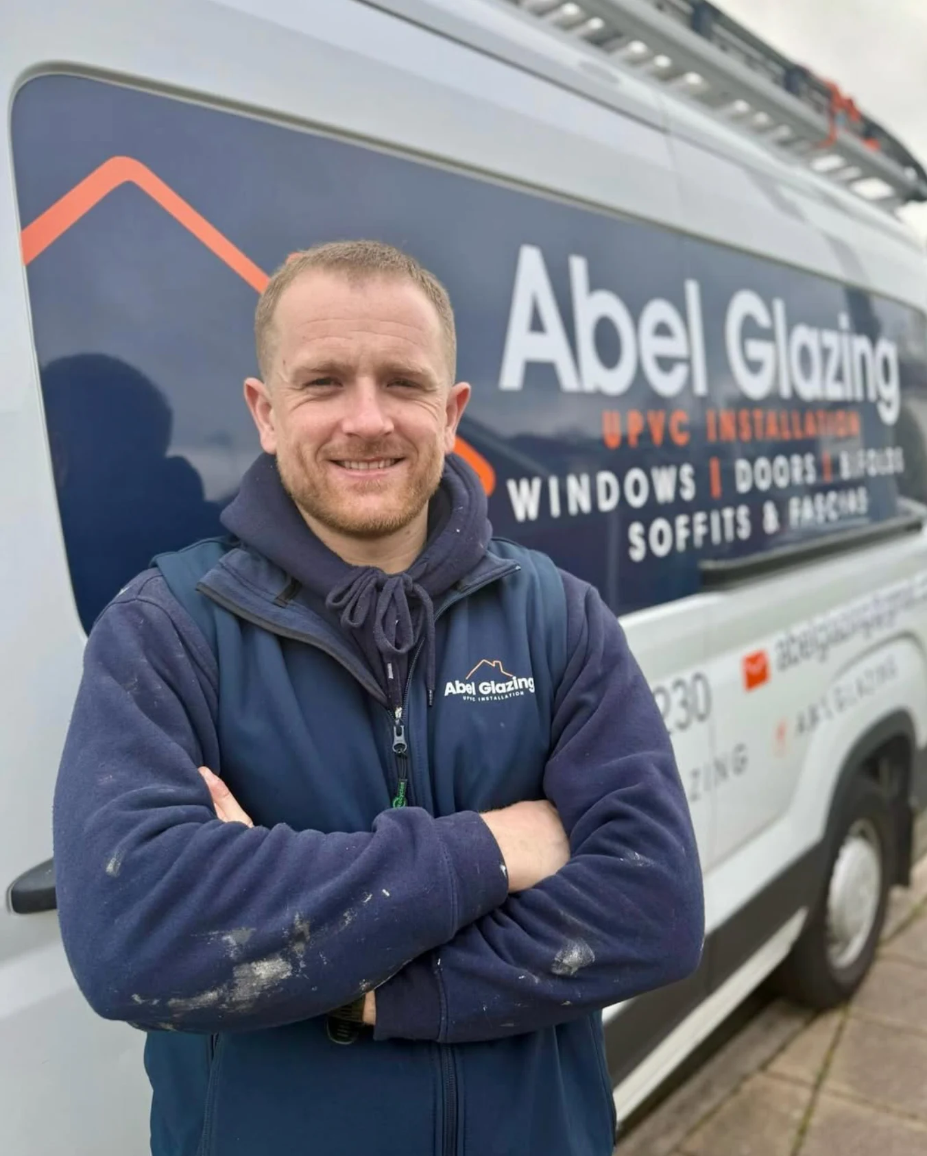 Abel Glazing’s fitter standing beside the branded installation van